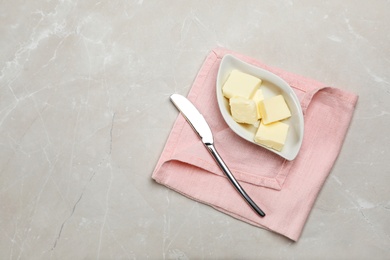 Photo of Plate with tasty fresh butter and knife on table, top view