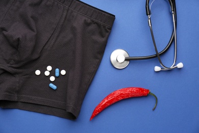 Flat lay composition with men's underwear and chili pepper on blue background. Potency problem concept