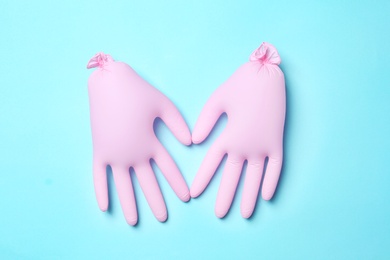 Photo of Inflated medical gloves on color background, top view