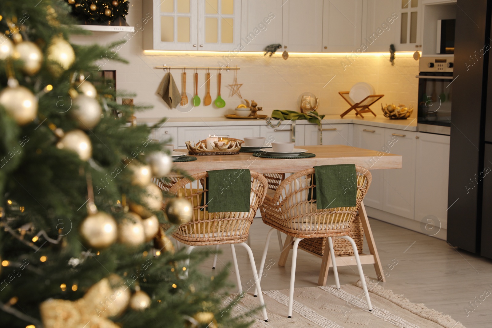 Photo of Beautiful Christmas tree in spacious kitchen, closeup. Space for text