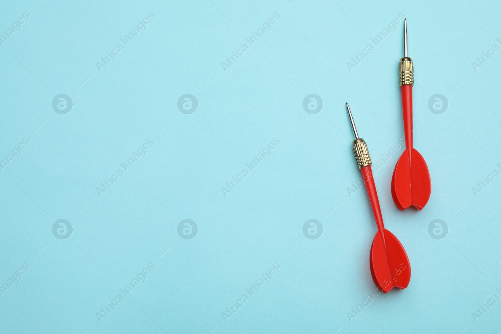 Photo of Red dart arrows on blue background, flat lay with space for text