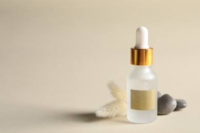 Composition with bottle of cosmetic serum on beige background. Space for text