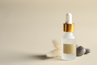 Photo of Composition with bottle of cosmetic serum on beige background. Space for text