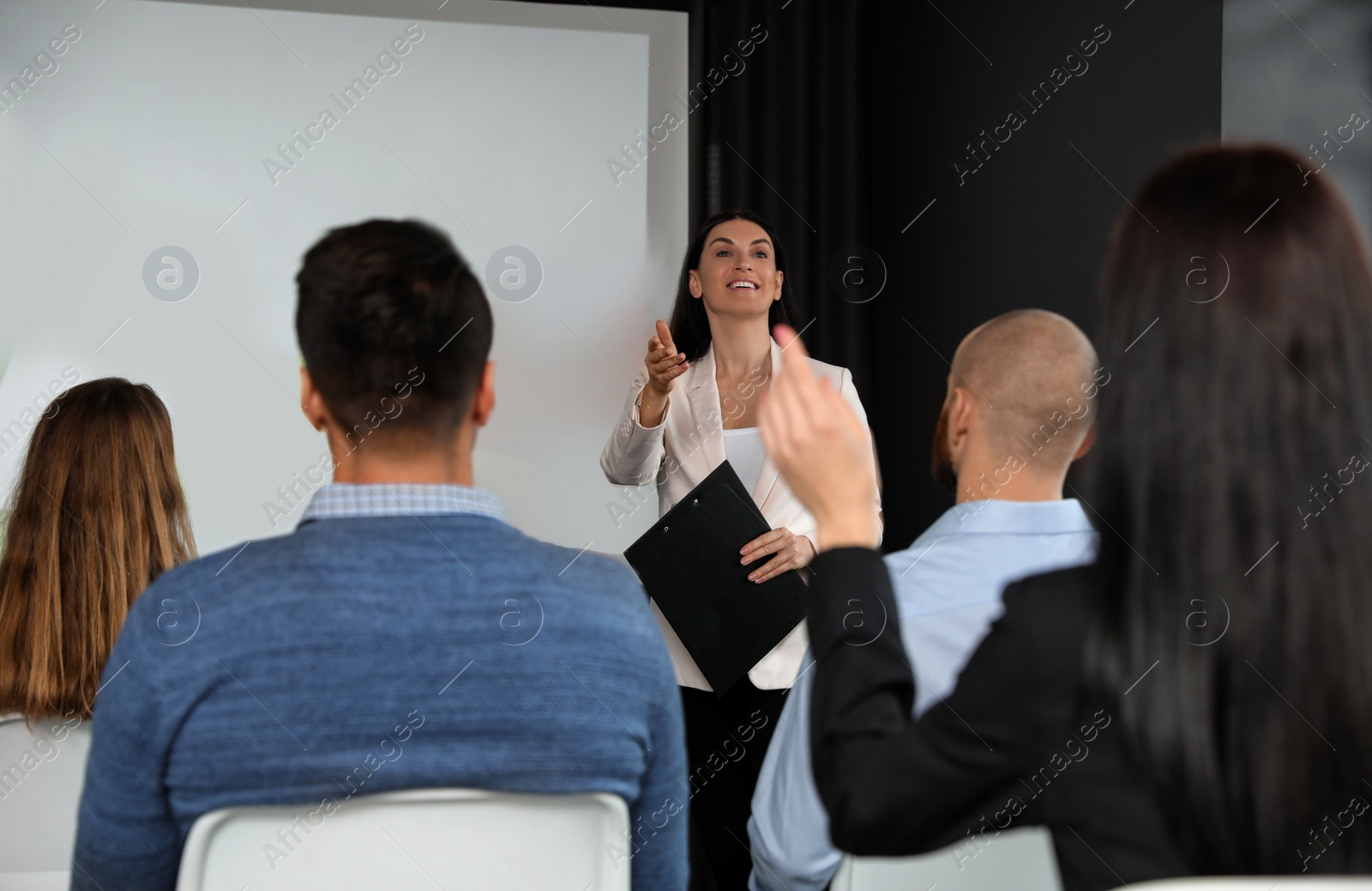 Photo of Business people at seminar in conference room with video projection screen