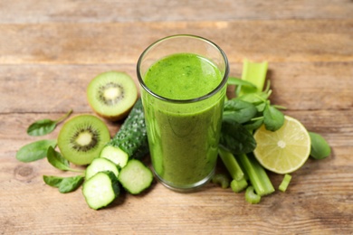 Delicious green juice and fresh ingredients on wooden table