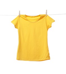 Photo of Yellow t-shirt drying on washing line against white background