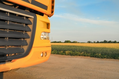 Photo of Modern yellow truck on country road, closeup. Space for text
