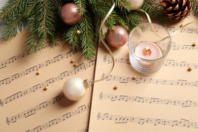 Composition with Christmas decorations on music sheets, above view