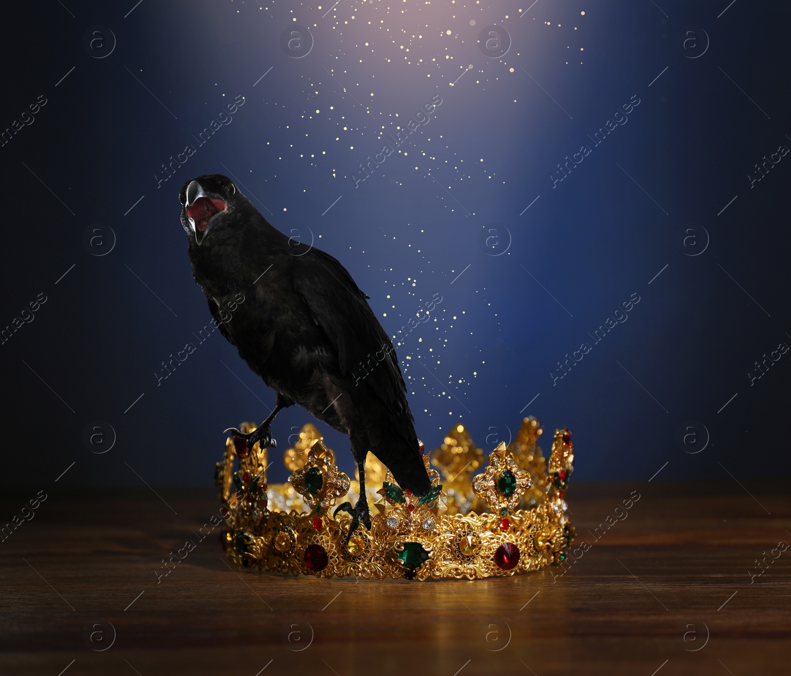 Image of Fantasy world. Black crow lit by magic light sitting on golden crown 