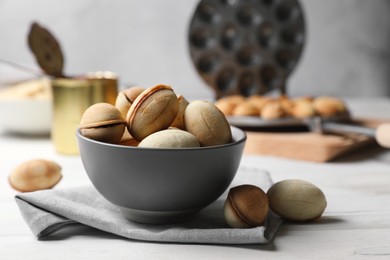 Photo of Delicious walnut shaped cookies with condensed milk on white wooden table, closeup