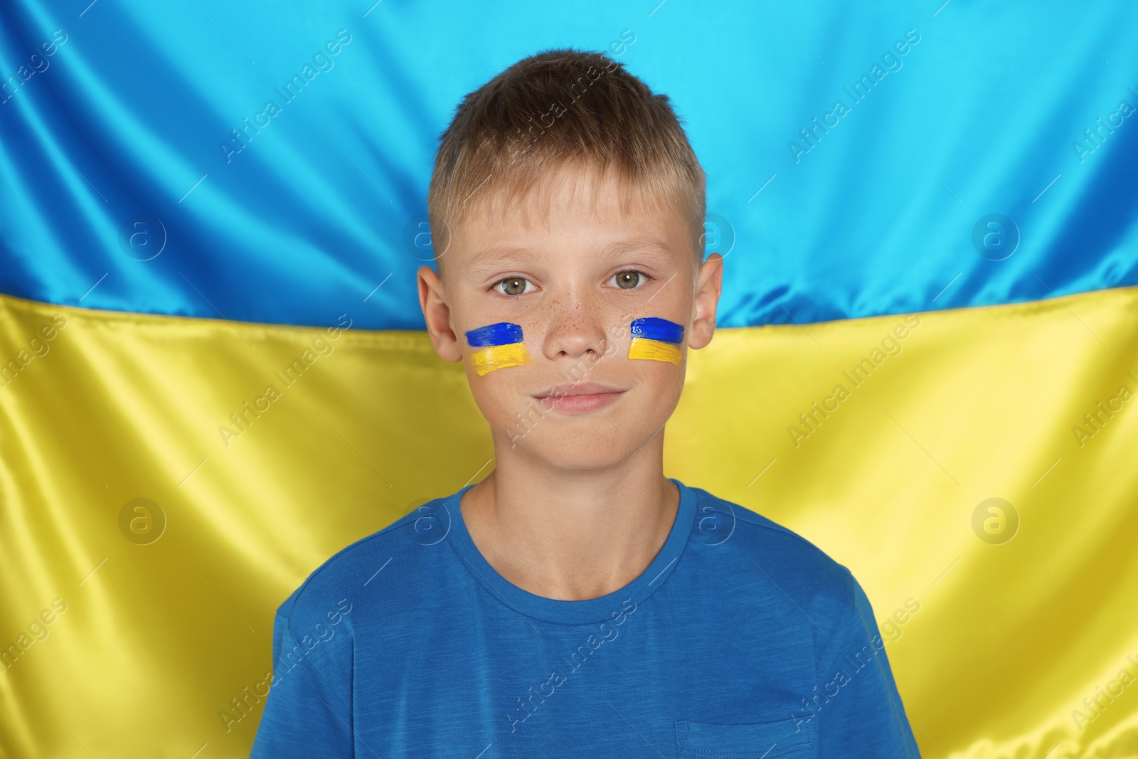 Photo of Little boy near Ukrainian flag. No war concept