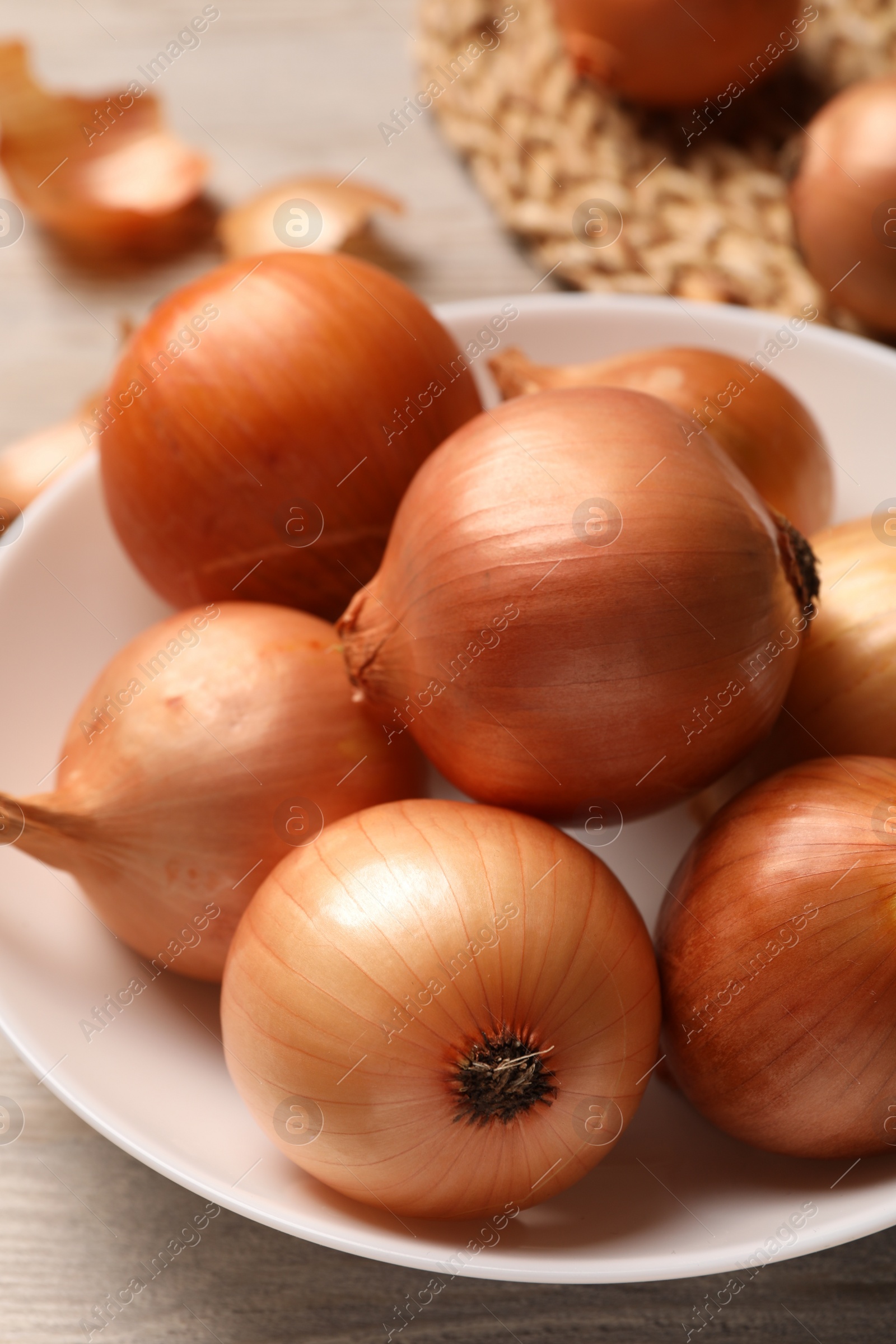 Photo of Many ripe onions on wooden table, closeup