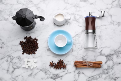 Photo of Flat lay composition with manual coffee grinder and beans on white marble table