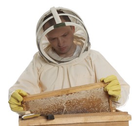 Photo of Beekeeper in uniform taking frame with honeycomb out of wooden hive on white background