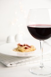 Photo of Delicious Carbonara pasta, focus on glass of wine. Space for text