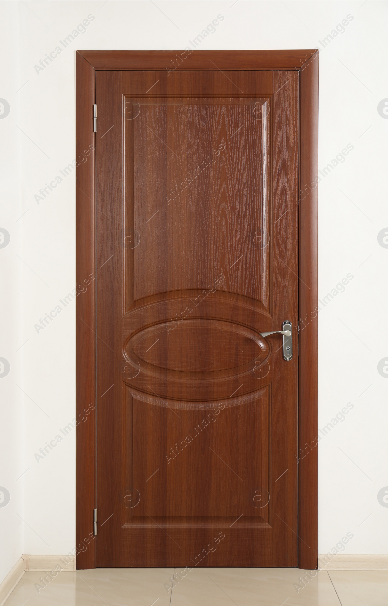 Photo of Closed brown wooden door in white wall