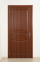 Photo of Closed brown wooden door in white wall