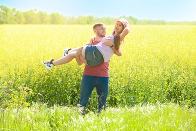 Happy young couple in green field on sunny spring day