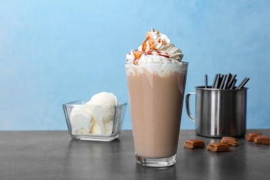 Glass with delicious milk shake on table