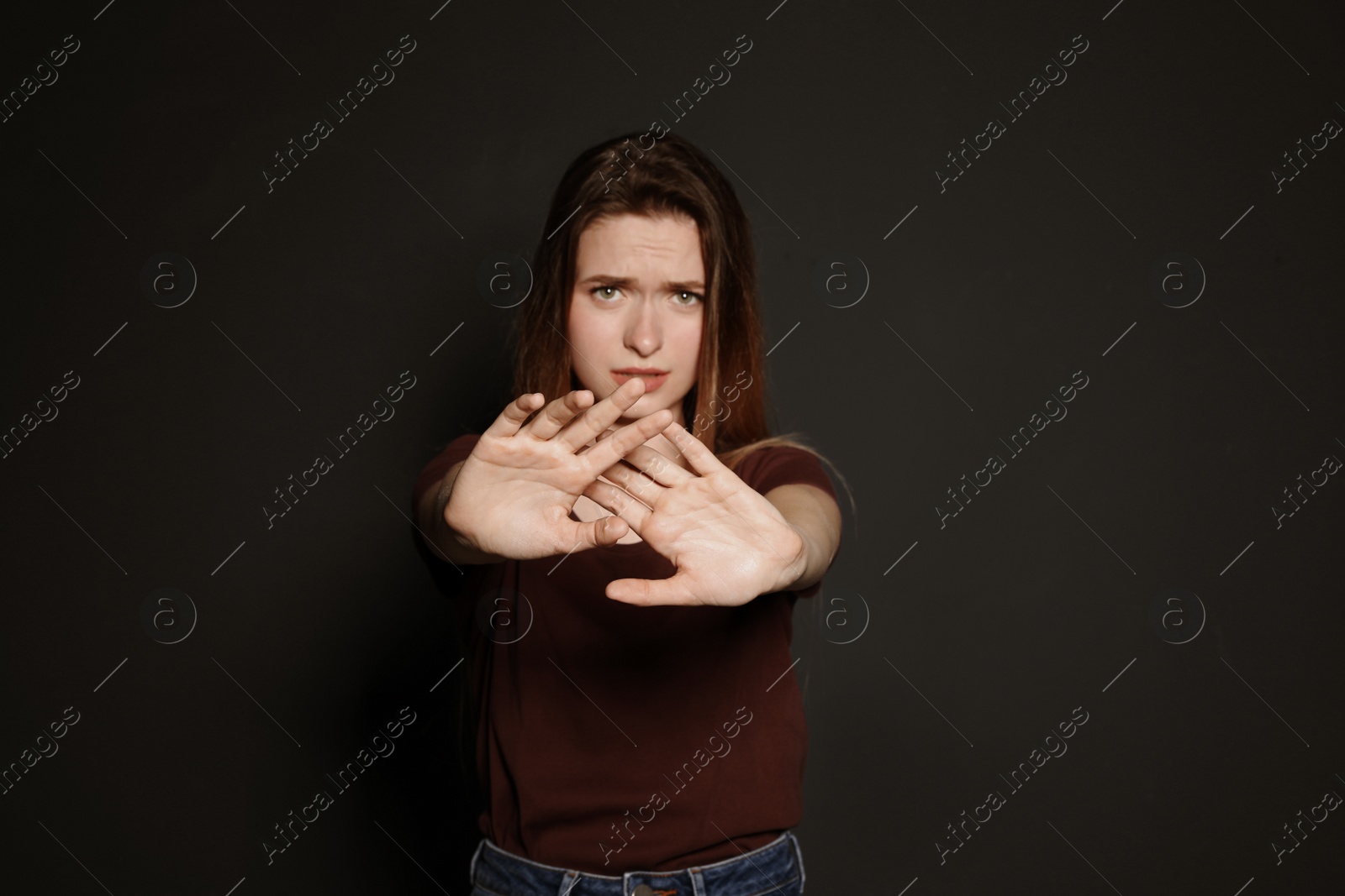 Photo of Young woman making stop gesture against dark background