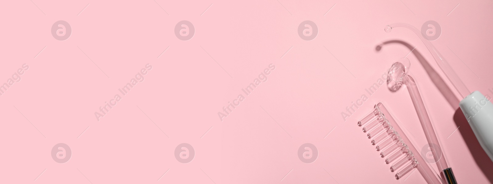 Image of High frequency darsonval device and different nozzles on pink background, flat lay. Banner design with space for text