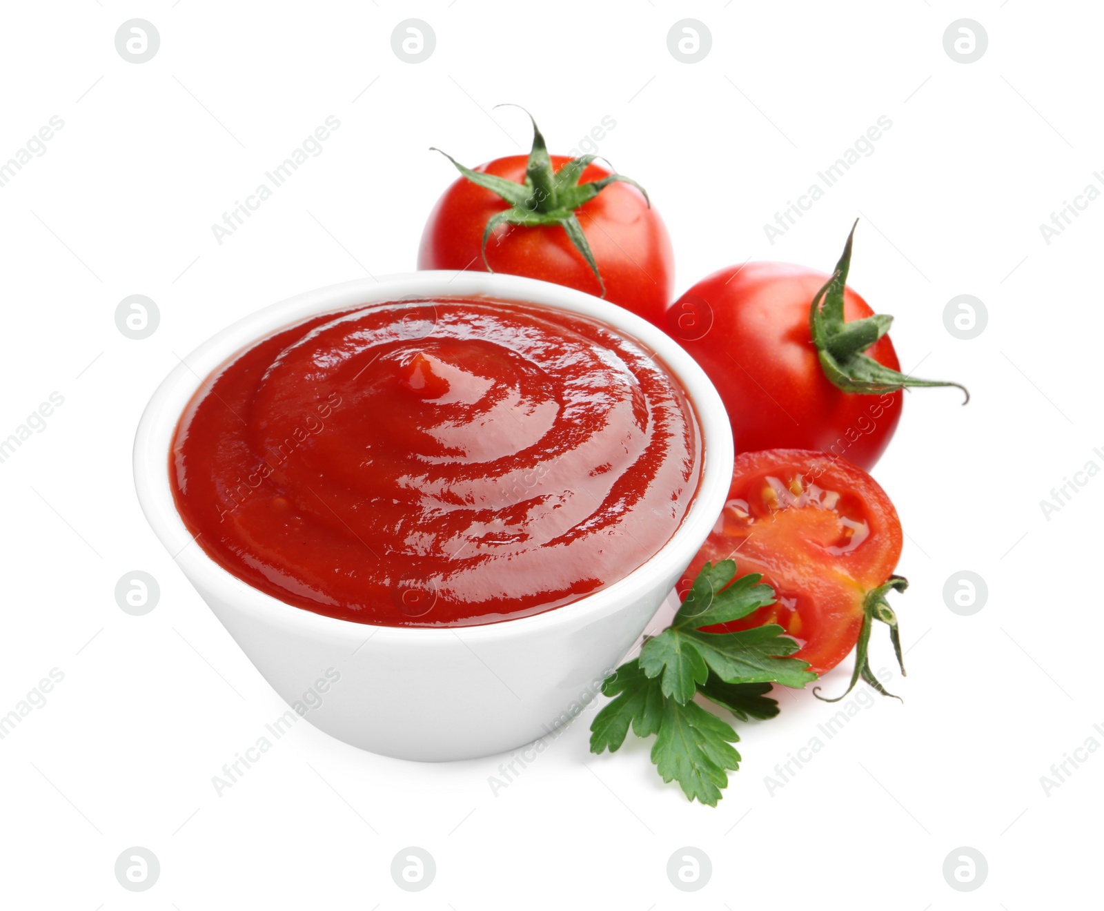 Photo of Tasty ketchup in bowl, parsley and fresh tomatoes isolated on white