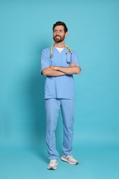Photo of Full length portrait of doctor on light blue background