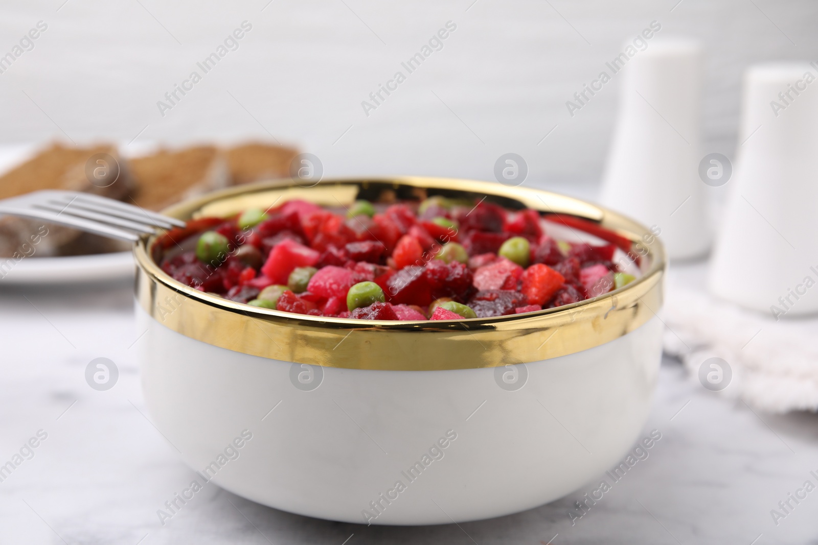 Photo of Delicious vinaigrette salad on white marble table, closeup