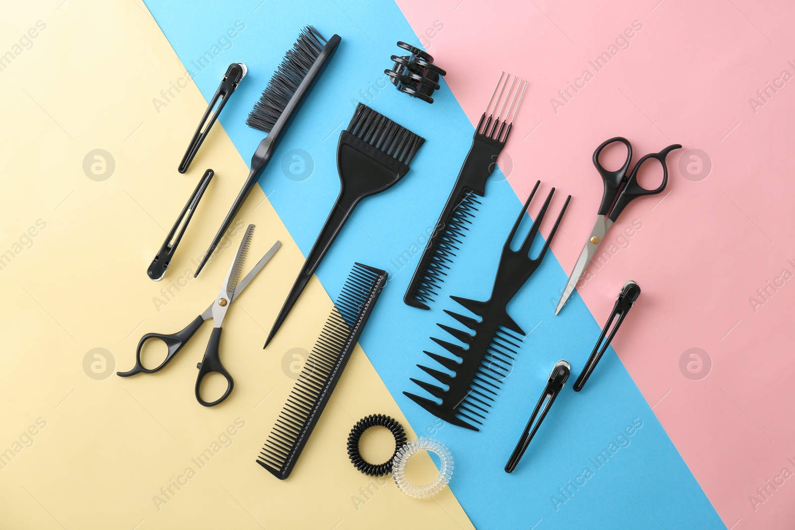 Photo of Flat lay composition with professional hairdresser tools on color background