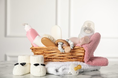 Photo of Baby booties and accessories on white marble table indoors