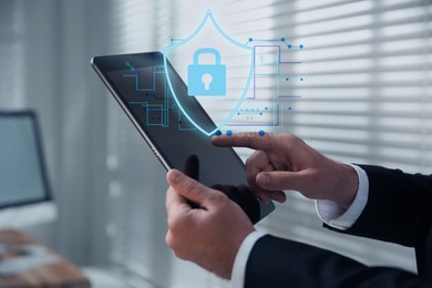 Image of Privacy protection. Man using tablet in office, closeup. Digital scheme with illustration of shield with padlock over device