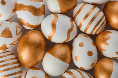 Photo of Traditional Easter eggs decorated with golden paint, top view
