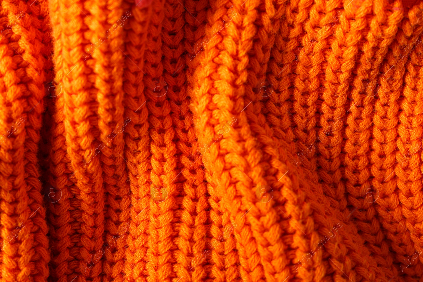 Photo of Texture of knitted orange fabric as background, closeup