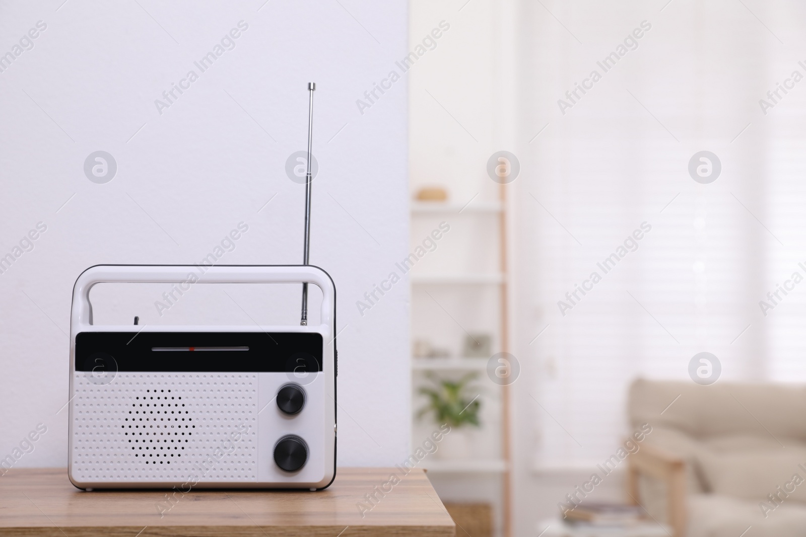 Photo of Stylish white radio on table indoors. Space for text