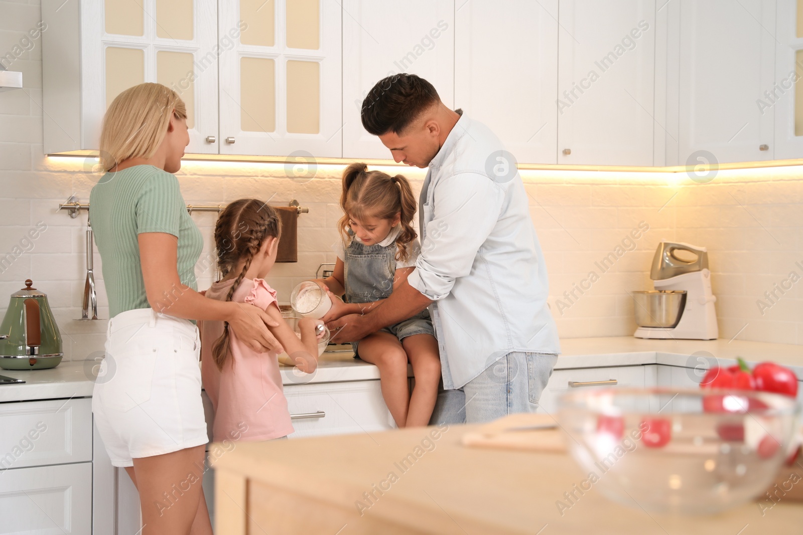 Photo of Happy family cooking together in modern kitchen