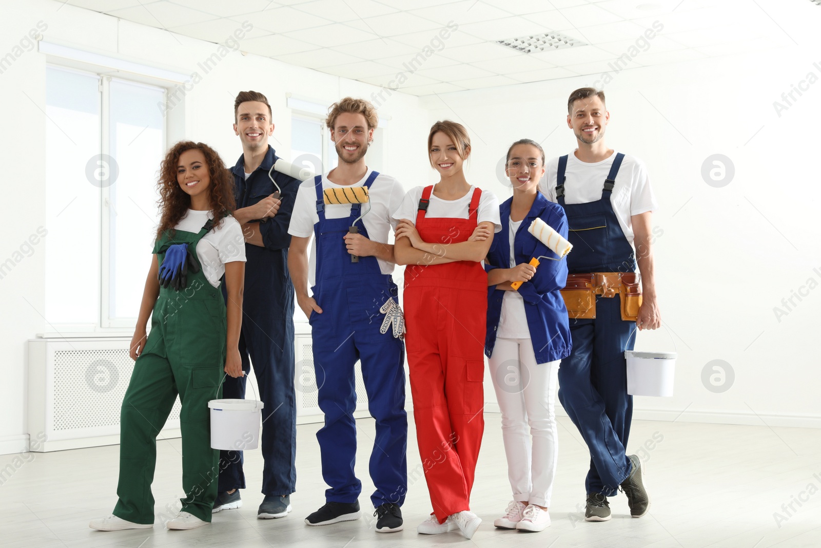 Photo of Team of professional painters with tools indoors