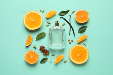 Flat lay composition with bottle of perfume and fresh citrus fruits on turquoise background