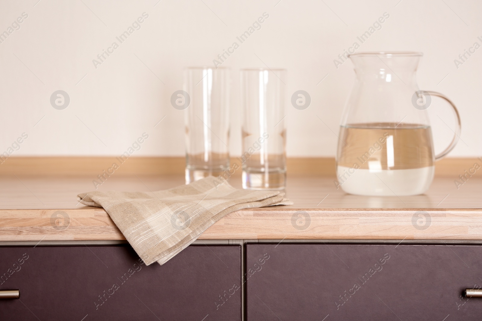 Photo of Fabric checkered towel on wooden table in kitchen