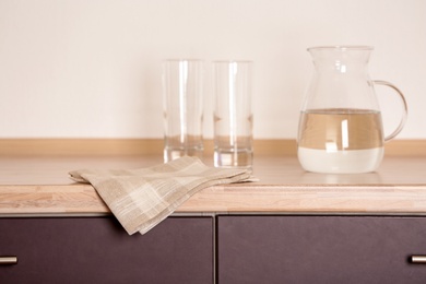 Photo of Fabric checkered towel on wooden table in kitchen