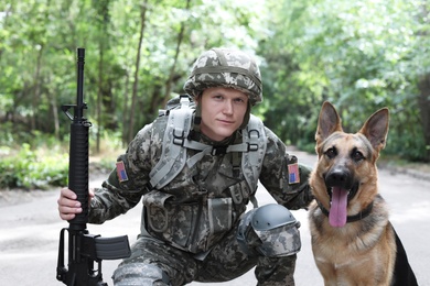 Man in military uniform with German shepherd dog, outdoors