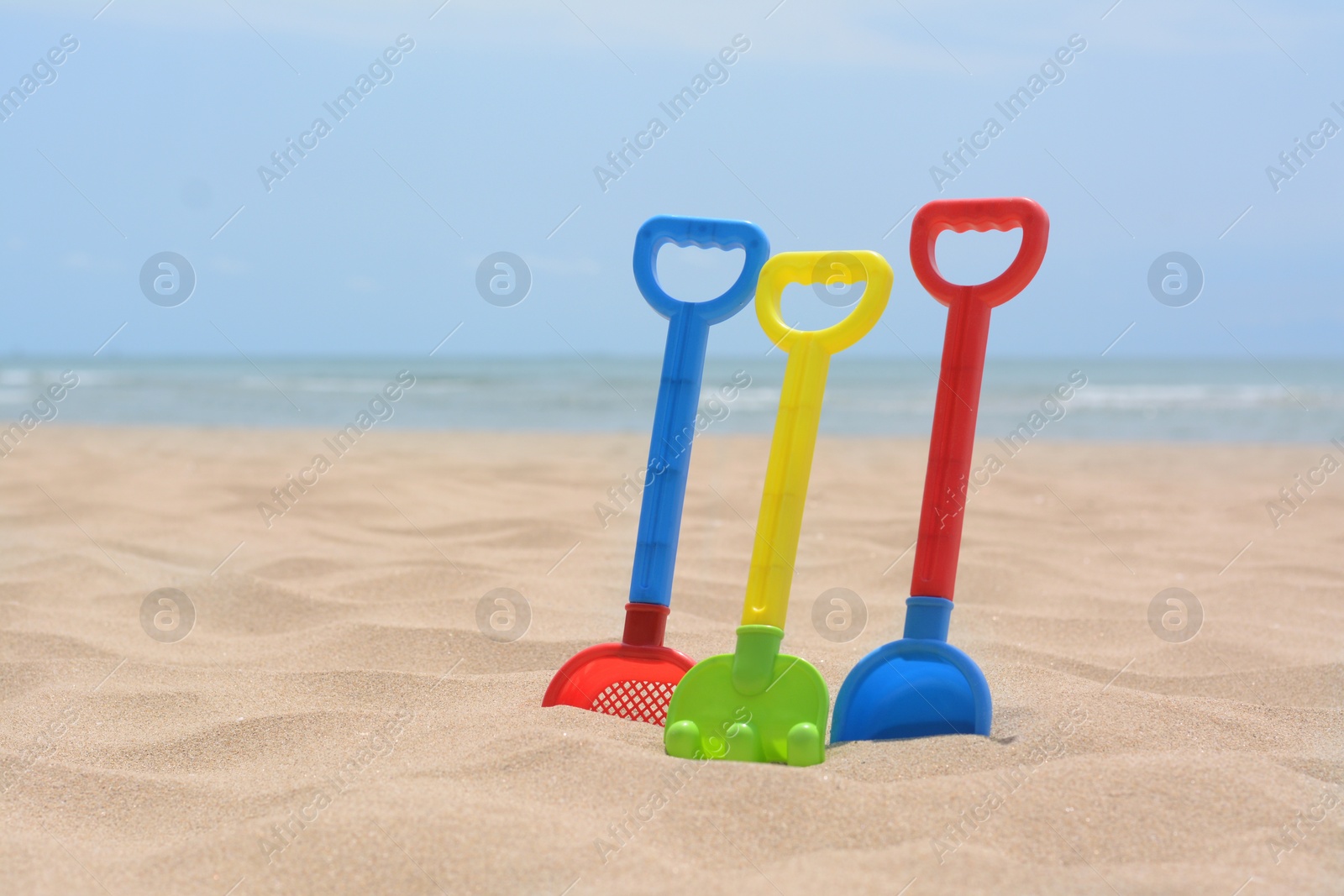 Photo of Set of colorful beach toys on sand near sea