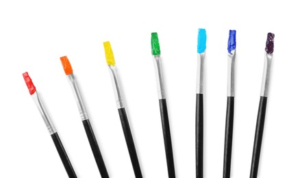 Photo of Brushes with colorful paints on white background, top view
