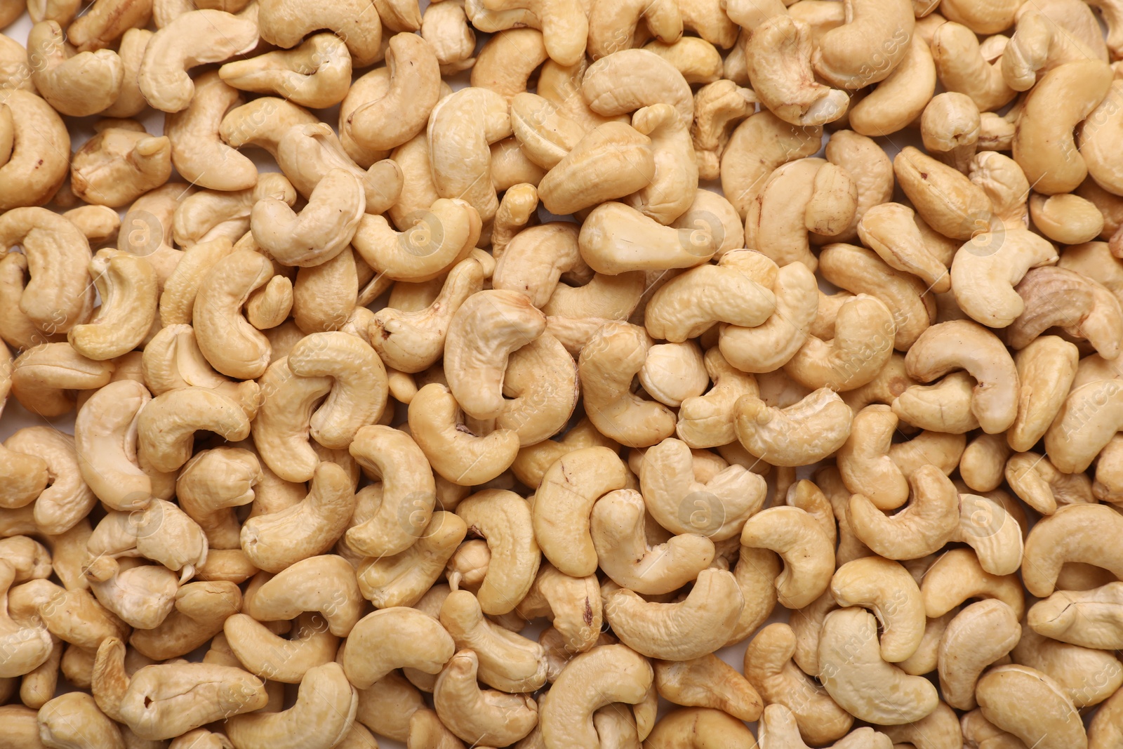 Photo of Many tasty cashew nuts as background, top view