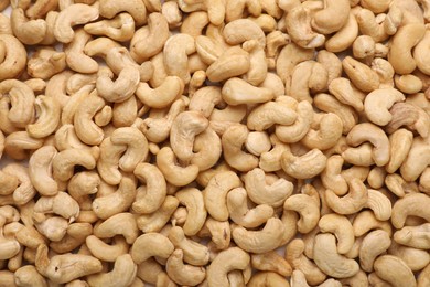 Many tasty cashew nuts as background, top view