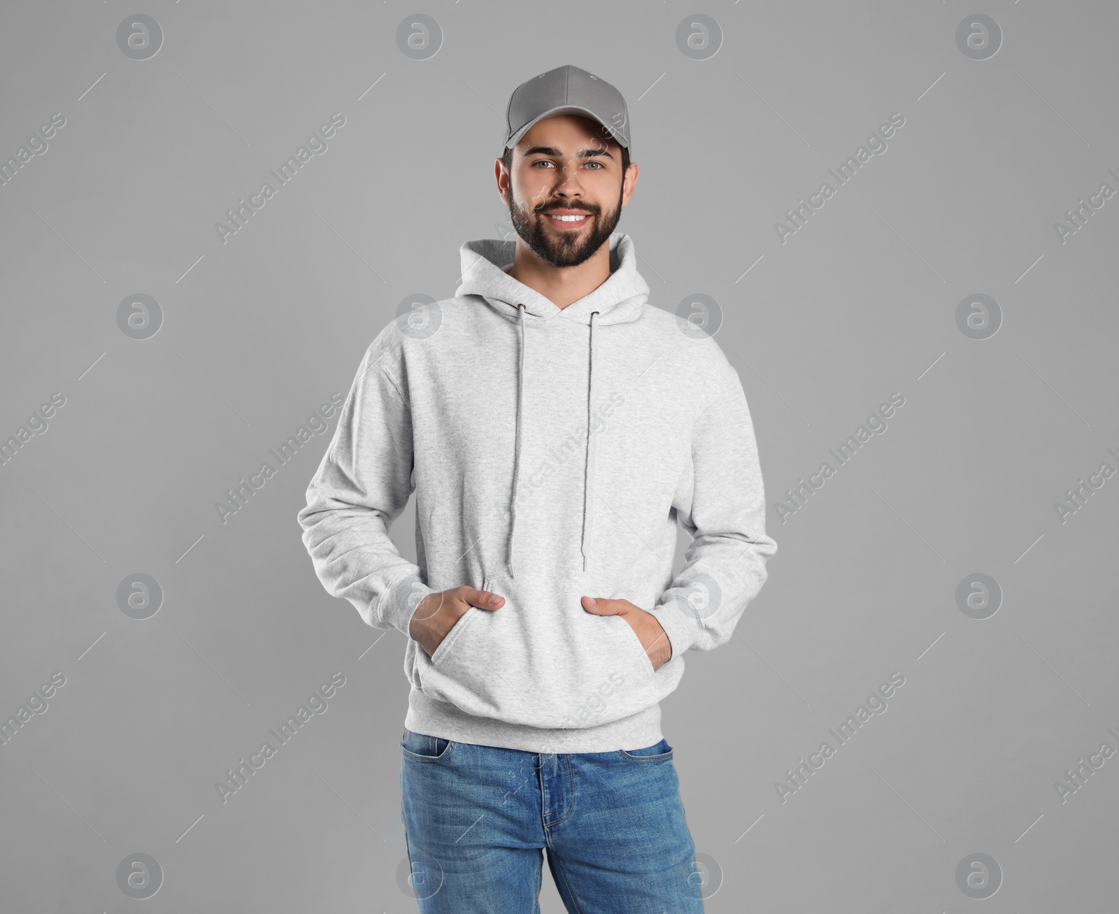 Photo of Portrait of young man in sweater on grey background. Mock up for design