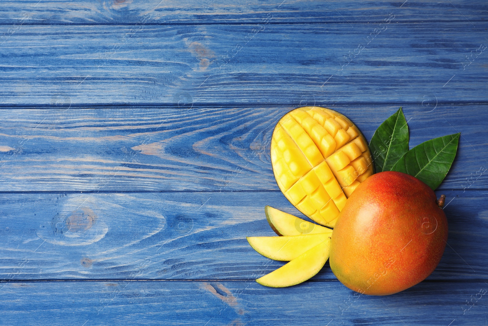 Photo of Flat lay composition with mango on wooden background. Space for text