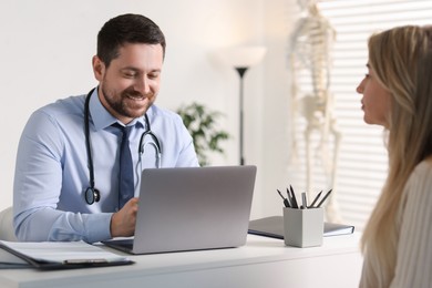 Photo of Professional doctor working with patient at white table in hospital