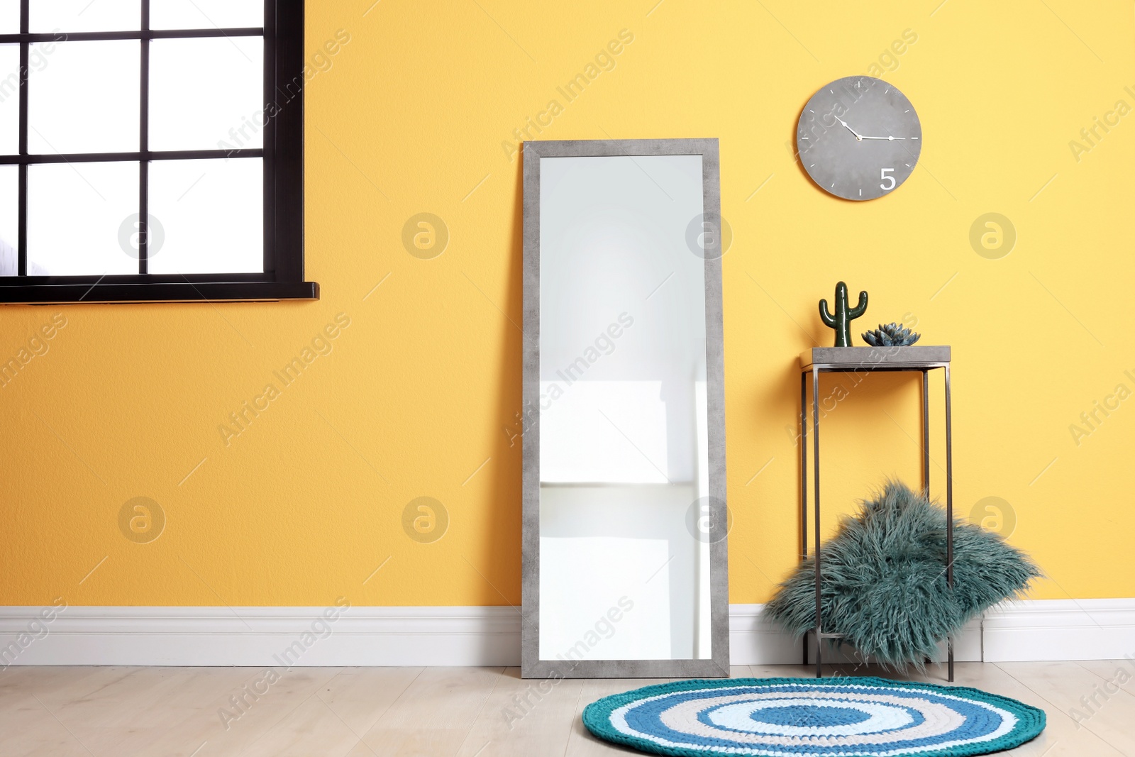 Photo of Elegant room interior with mirror near color wall