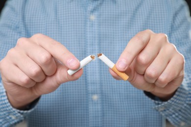 Stop smoking concept. Man holding pieces of broken cigarette, closeup