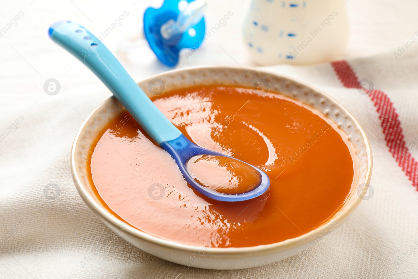 Photo of Bowl of healthy baby food on table, closeup